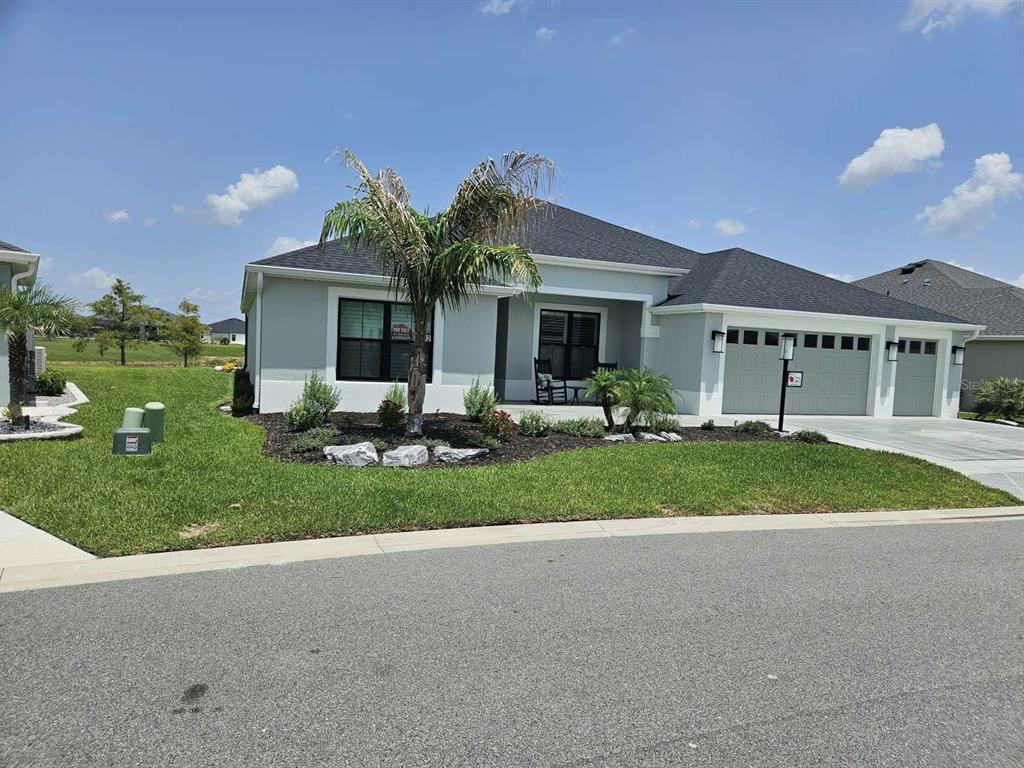 A single-story house with a gray exterior, a dark shingled roof, and a two-car garage — 7602 FRANK DIPIETRO DRIVE, THE VILLAGES, FL