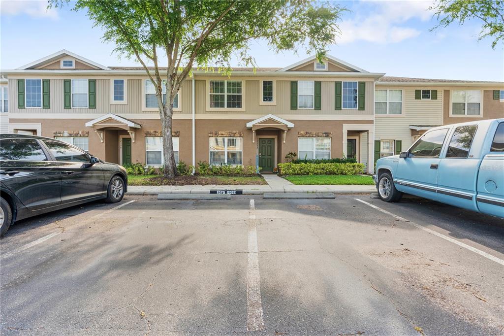 A two-story townhouse exterior with a parking lot in the foreground — 12322 FOXMOOR PEAK DRIVE, RIVERVIEW, FL