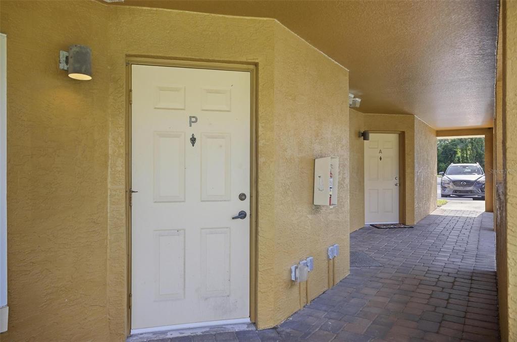 A view of two exterior apartment doors labeled P and A along a paved walkway — 4600 E MOODY BOULEVARD UNIT 1P, BUNNELL, FL
