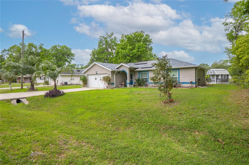 A single-story house with a tan exterior, a two-car garage, and a large front lawn — 3956 S FERNPARK TERRACE, INVERNESS, FL