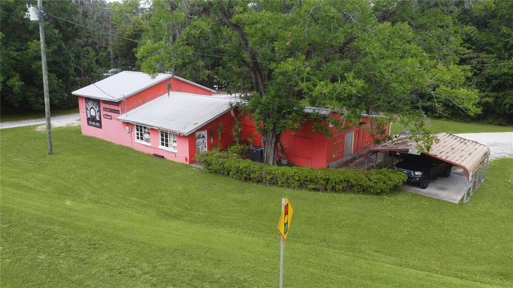 An aerial view of a red commercial building with a metal roof and carport — 7220 NE US HIGHWAY 301, HAWTHORNE, FL