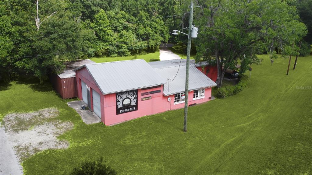 An aerial view of a pink commercial building with a metal roof and garage doors — 7220 NE US HIGHWAY 301, HAWTHORNE, FL