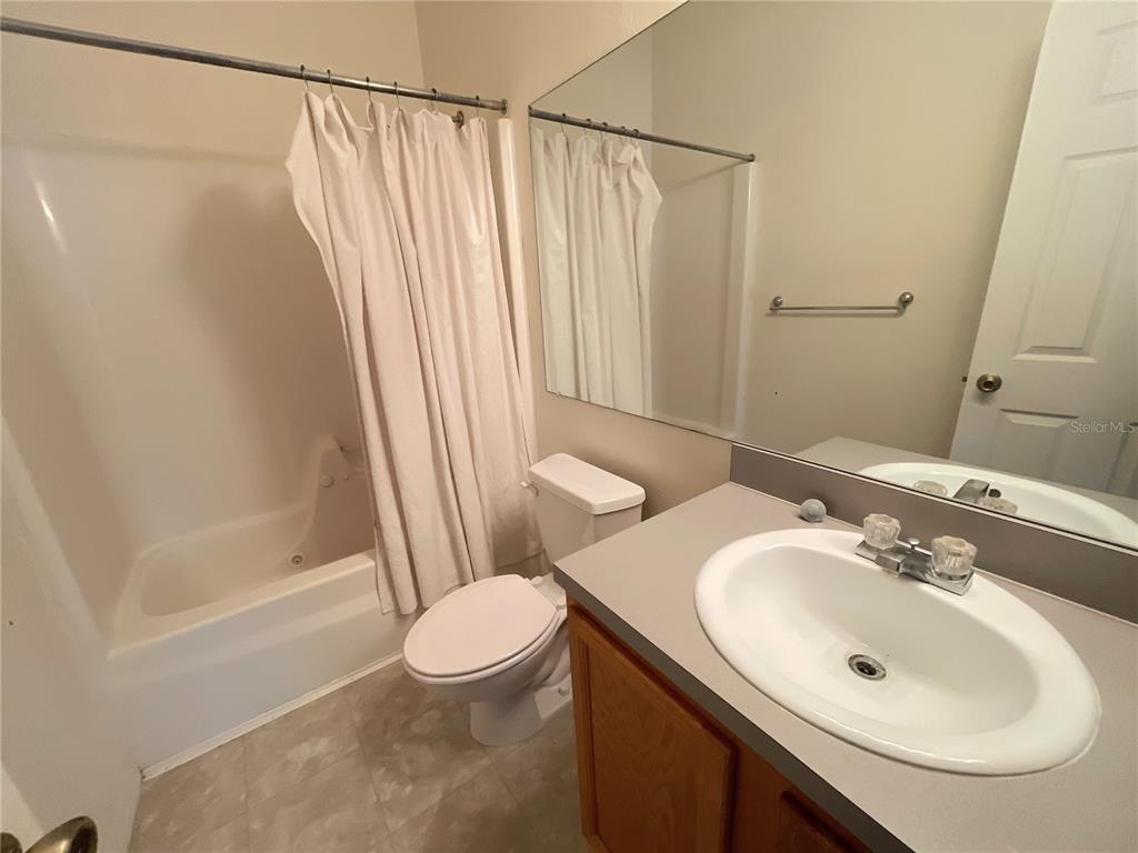 A bathroom features a vanity with a sink, a toilet, and a shower-tub combination — 3930 SW 20TH AVENUE UNIT 1902, GAINESVILLE, FL