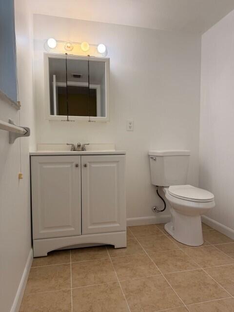 A bathroom features a white vanity with a sink, a medicine cabinet, and a toilet — 3001 Linton Boulevard # 107c, Delray Beach FL 33445, DELRAY BEACH, FL
