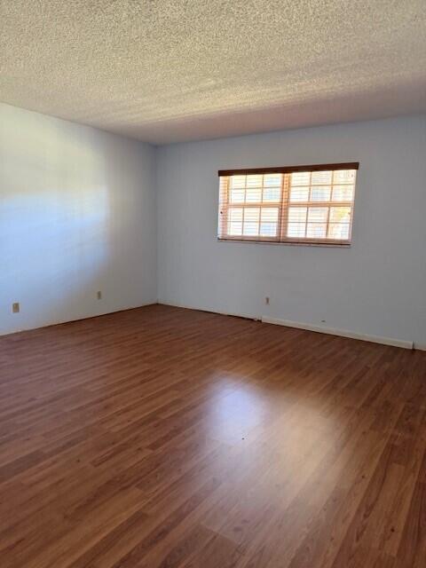 An empty room with light blue walls, wood-look flooring, and a window with blinds — 3001 Linton Boulevard # 107c, Delray Beach FL 33445, DELRAY BEACH, FL