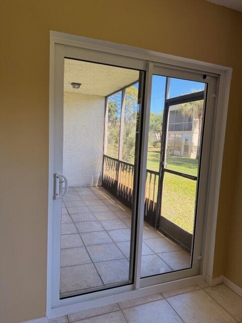 A white sliding glass door opens onto a tiled, screened-in patio overlooking a grassy area — 3001 Linton Boulevard # 107c, Delray Beach FL 33445, DELRAY BEACH, FL