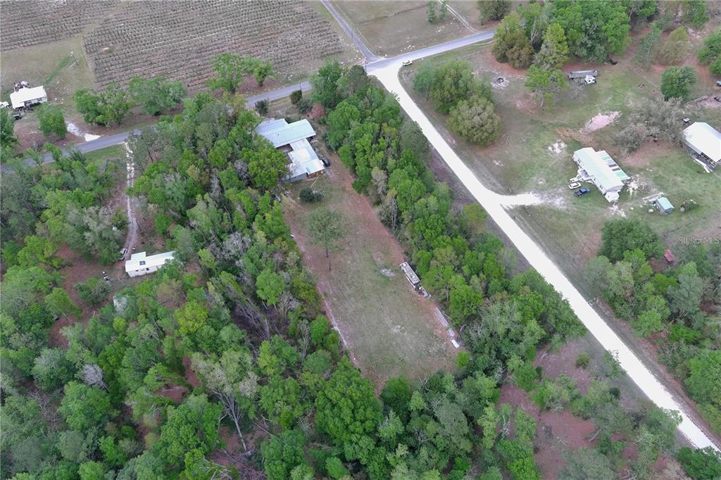 An aerial view shows a rural property with a house, outbuildings, and a grassy clearing — 0 144TH STREET, LIVE OAK, FL