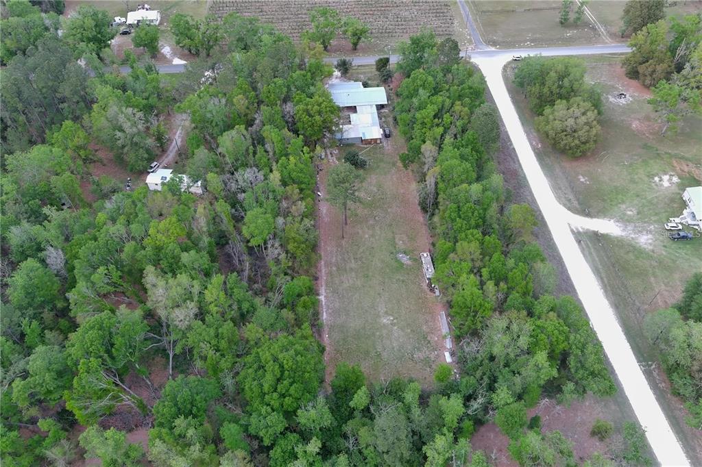 An aerial view shows a house on a long, narrow lot surrounded by dense trees — 0 144TH STREET, LIVE OAK, FL