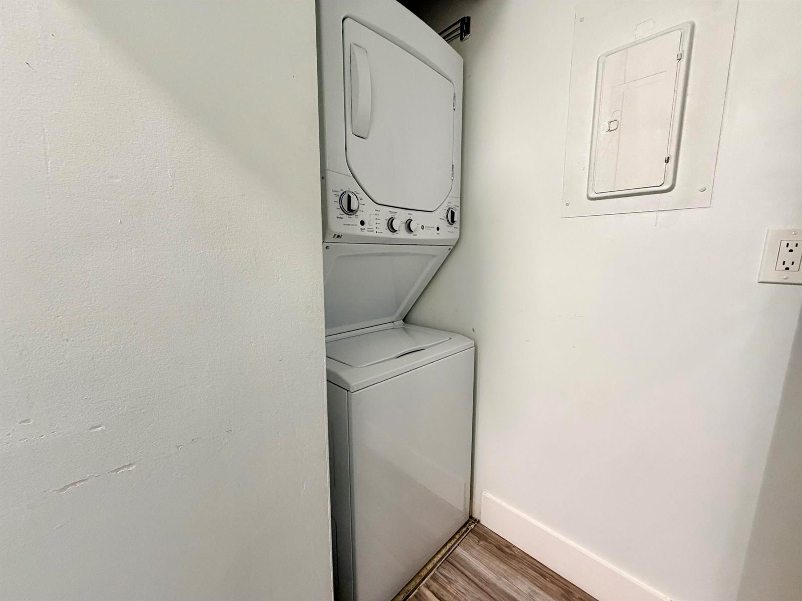 A white stacked washer and dryer unit is installed in a small laundry closet — 616 Sea Pine Way # C3, FL 33415, FL