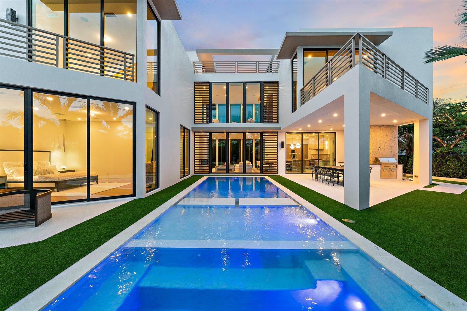 A modern two-story house with a swimming pool, artificial turf, and a covered outdoor kitchen — 390 Jupiter Lane, Juno Beach FL 33408, JUNO BEACH, FL