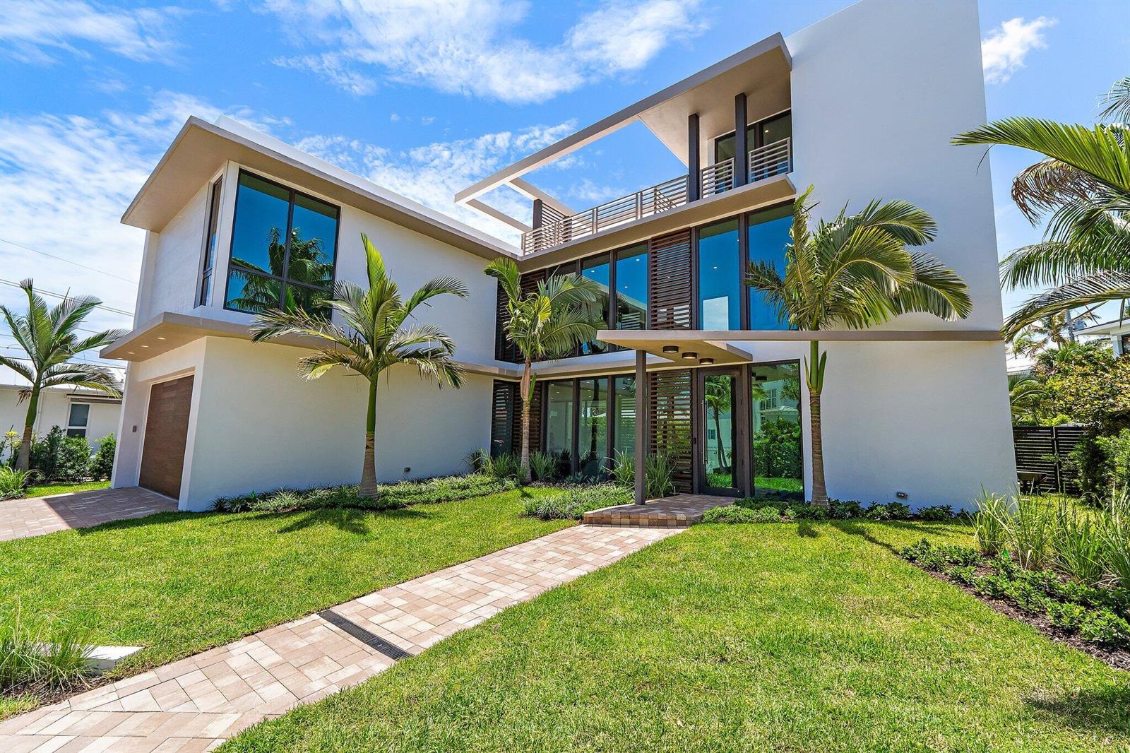 A modern two-story white house with large windows, a paved walkway, and palm trees — 390 Jupiter Lane, Juno Beach FL 33408, JUNO BEACH, FL