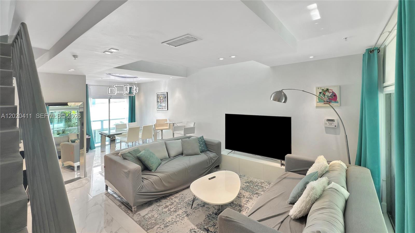 A modern, open-concept living area features a high ceiling, lofted walkway, and adjacent kitchen — 734 Michigan Ave # 6, Miami Beach FL 33139, MIAMI BEACH, FL