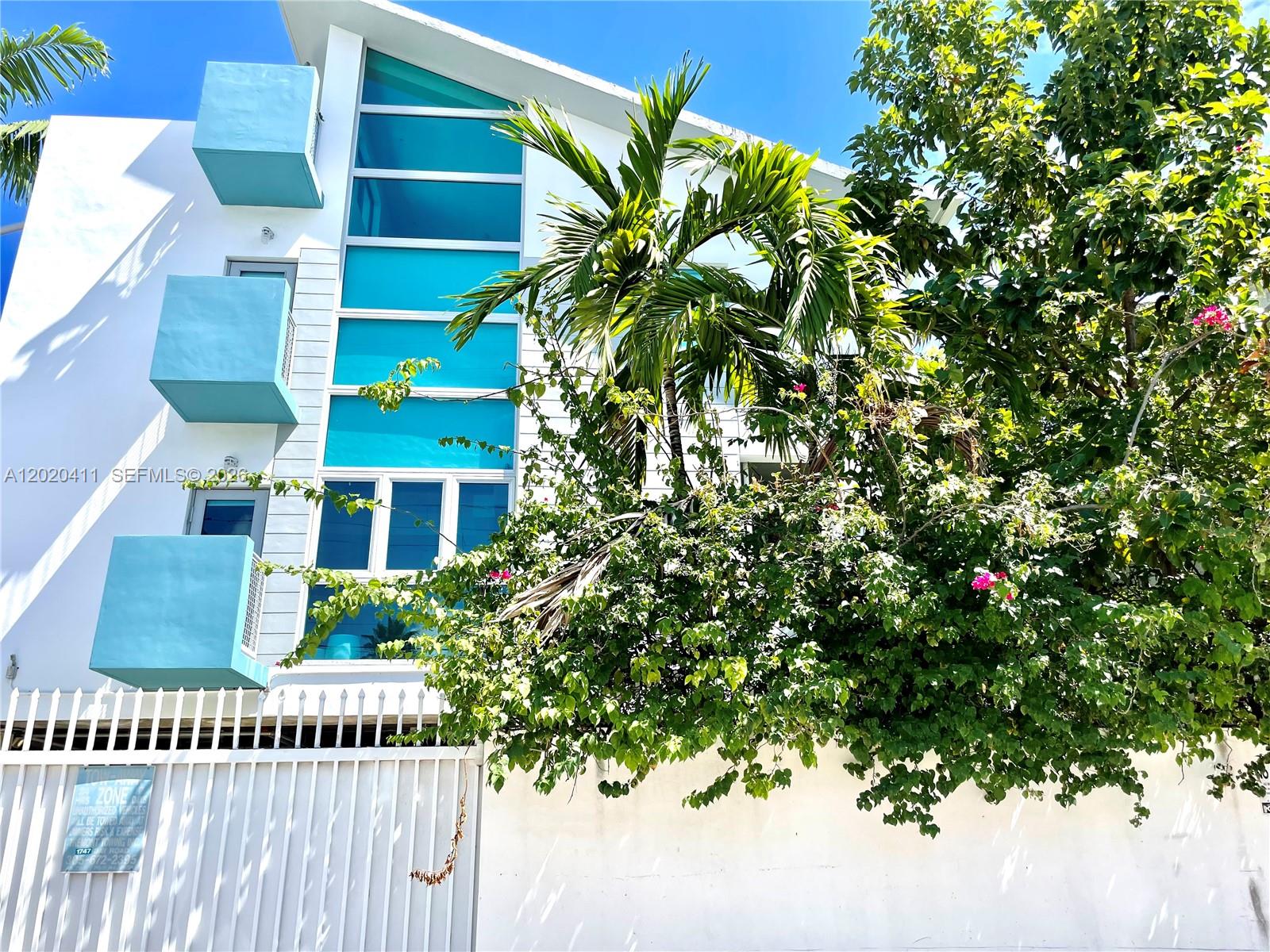 A living room features two gray sofas, a white coffee table, and a dining area — 734 Michigan Ave # 6, Miami Beach FL 33139, MIAMI BEACH, FL