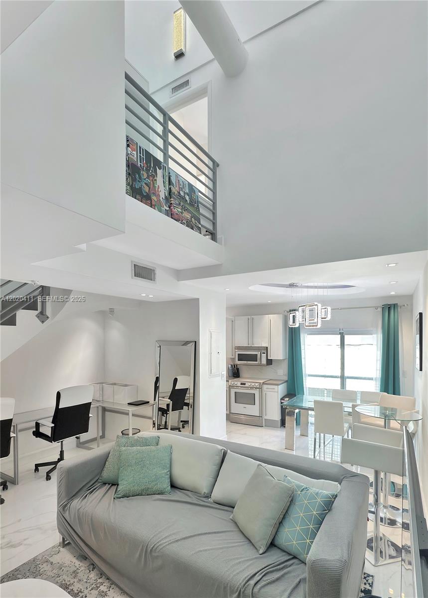 An exterior view of a modern building entrance with stairs leading up to a doorway — 734 Michigan Ave # 6, Miami Beach FL 33139, MIAMI BEACH, FL