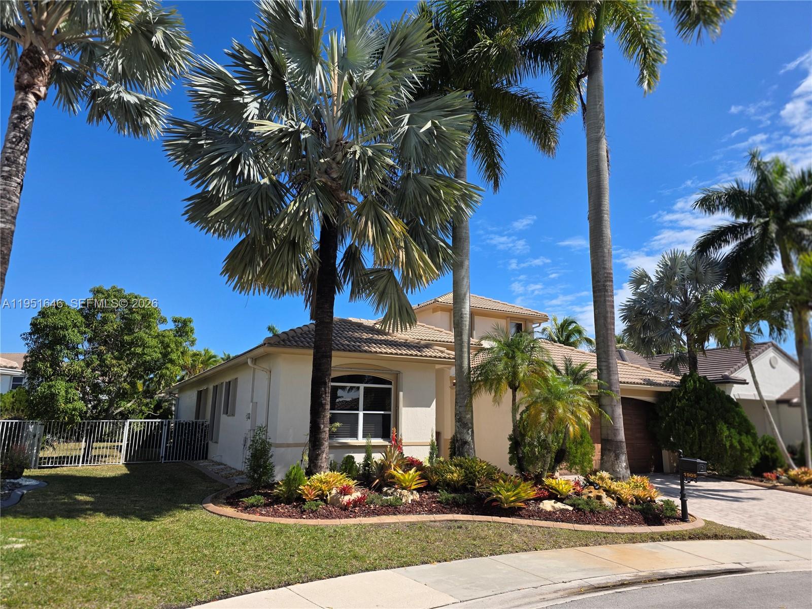 A single-story house with a tiled roof, palm trees, and a landscaped front garden — 1905 Harbor View Cir, Weston FL 33327, WESTON, FL