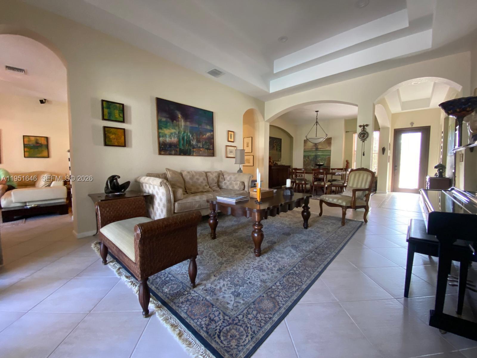 A living room features a coffered ceiling, tile flooring, a large area rug, and furniture — 1905 Harbor View Cir, Weston FL 33327, WESTON, FL
