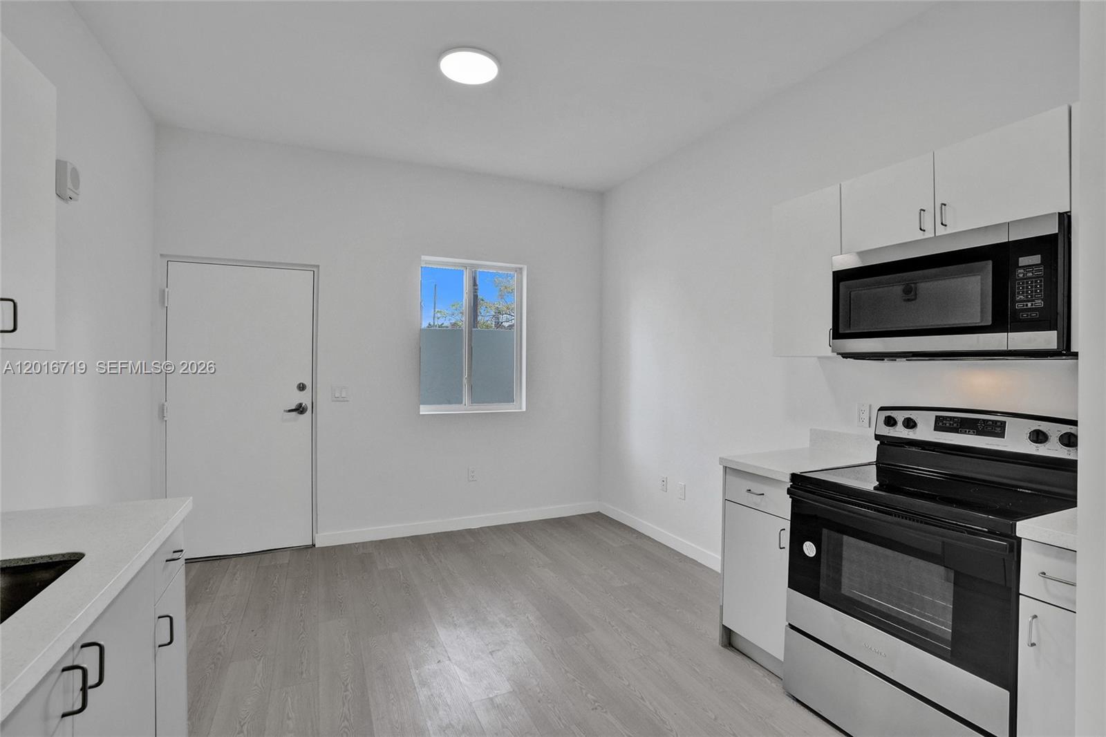 A kitchen with white cabinets, stainless steel appliances, and light wood-look flooring — 1567 NW 1st St # 2, Miami FL 33125, MIAMI, FL