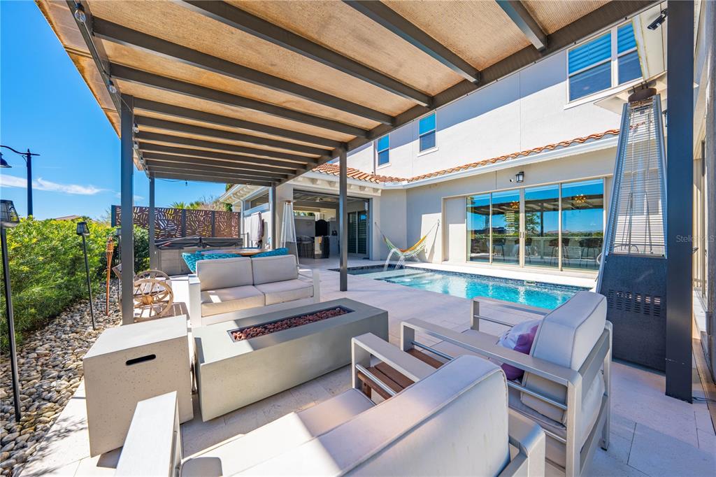 A patio features a fire pit, lounge seating, a pergola, and a swimming pool — 9406 MERE PARKWAY, ORLANDO, FL