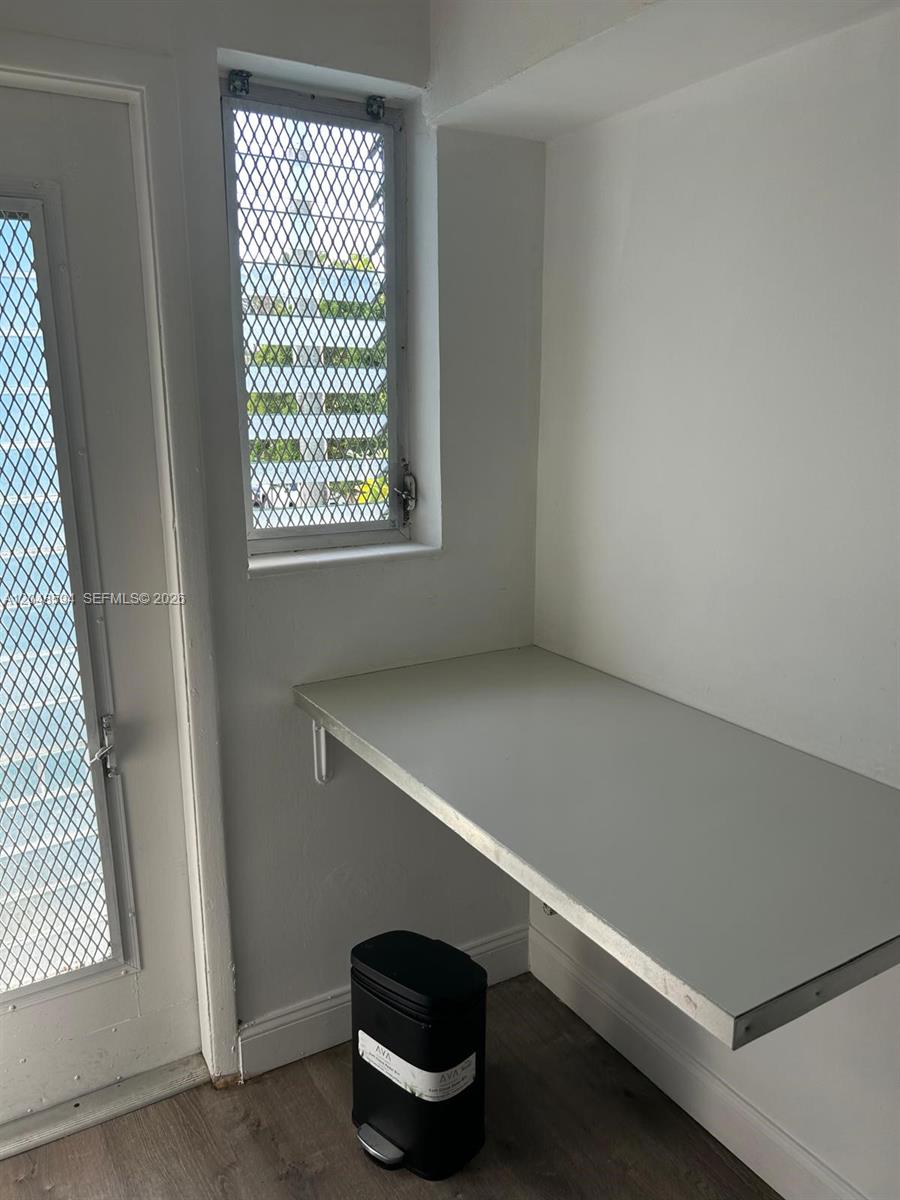 A small room features a wall-mounted desk, a window with security bars, and a trash can — 761 Euclid Ave # 9, Miami Beach FL 33139, MIAMI BEACH, FL