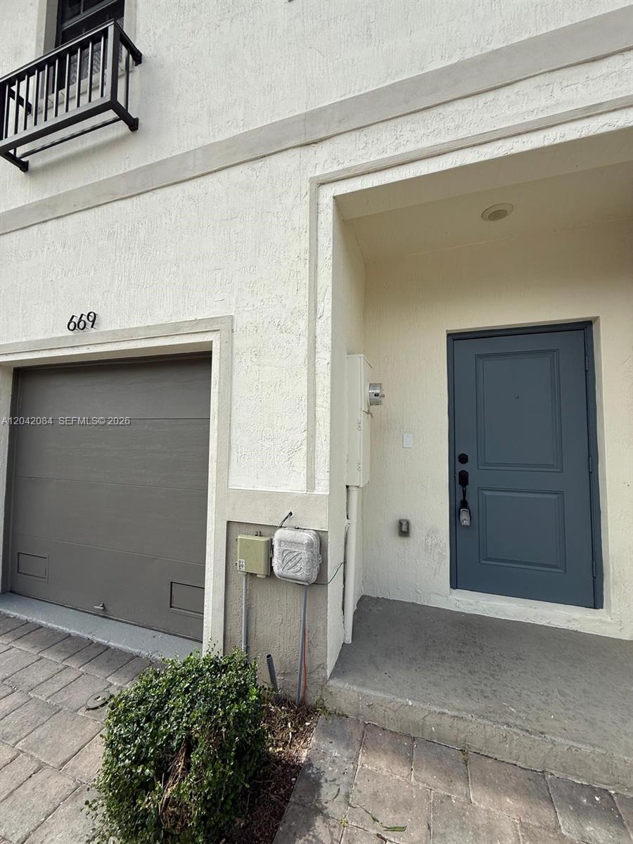 The exterior of a residential building features a garage, a front door, and a balcony — 669 SW 11th St, Florida City FL 33034, FLORIDA CITY, FL