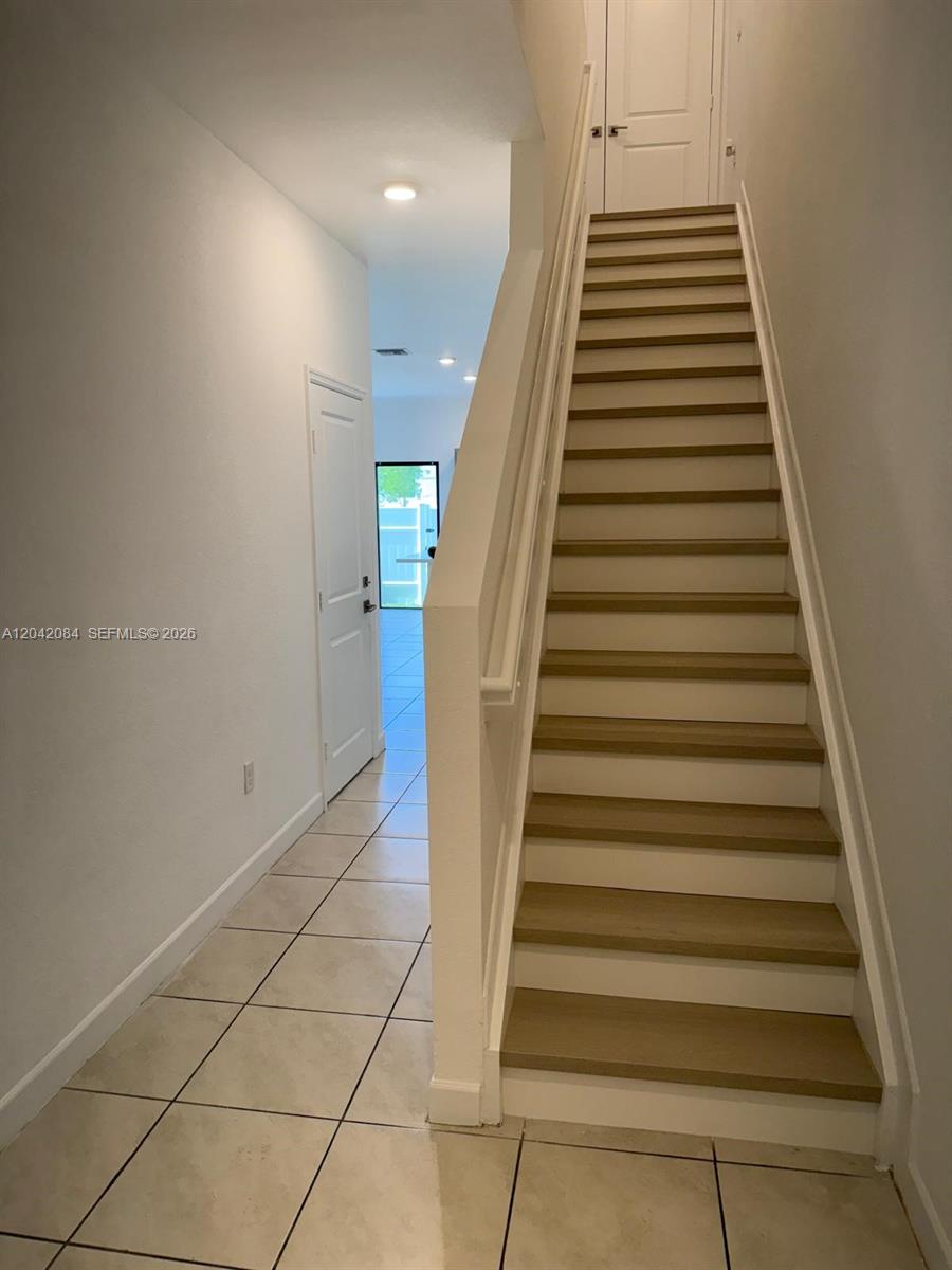A staircase with light wood treads and white risers leads to an upper level — 669 SW 11th St, Florida City FL 33034, FLORIDA CITY, FL