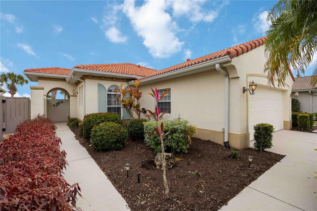 A single-story house with a tile roof, stucco exterior, and a front-facing garage — 242 MESTRE PLACE, NOKOMIS, FL