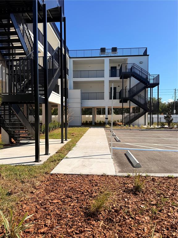 A multi-story apartment building features exterior metal staircases and a paved parking lot — 3601 6TH STREET S, ST PETERSBURG, FL