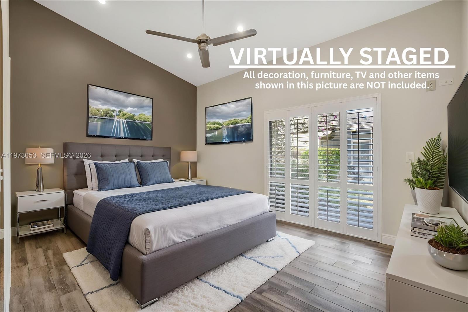 This open-concept living area features vaulted ceilings, wood-look flooring, and a kitchen with dark cabinetry — 349 NW 94th Ter, Plantation FL 33324, PLANTATION, FL