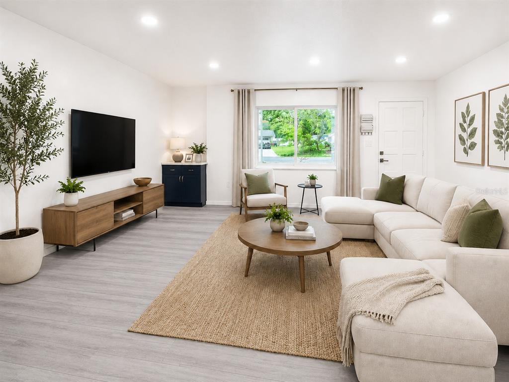 A living room features a sectional sofa, a wooden media console, and a round coffee table — 4302 NW 21ST DRIVE, GAINESVILLE, FL