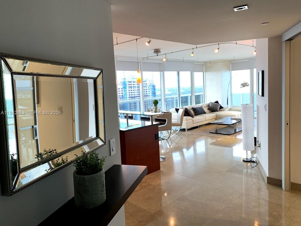 A modern apartment features a kitchen island, living area, and floor-to-ceiling windows with city views — 1830 S Ocean Dr # 4608, Hallandale Beach FL 33009, HALLANDALE BEACH, FL