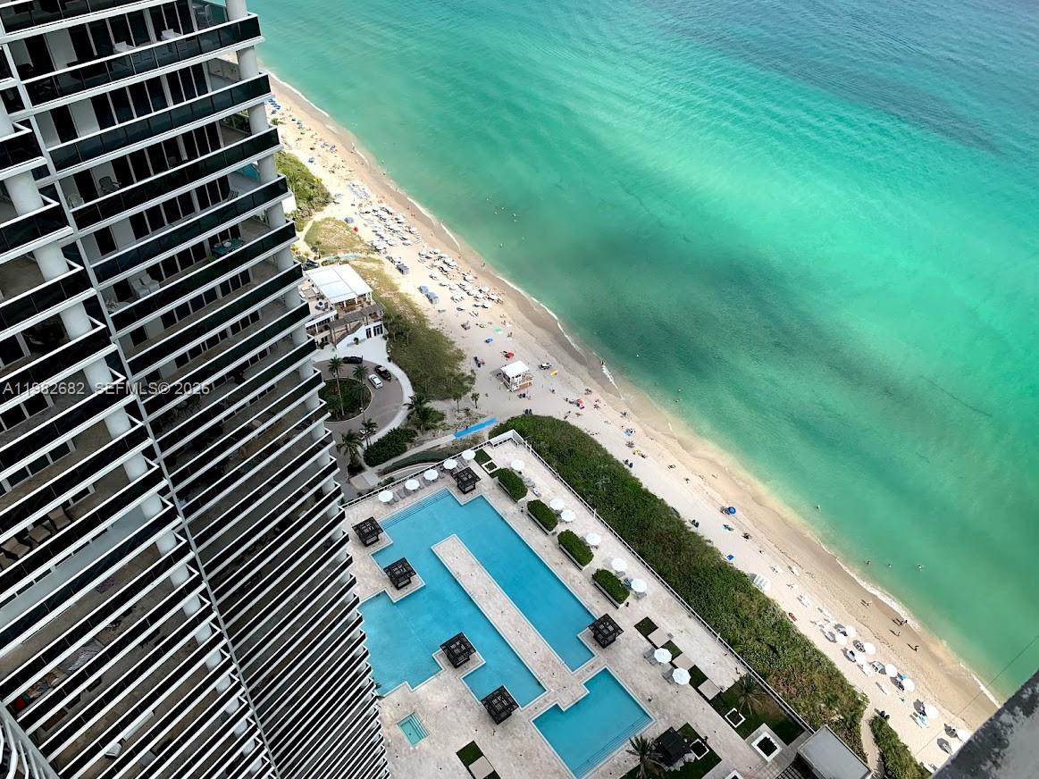 An aerial view shows a high-rise building, a multi-level swimming pool, and a sandy beach — 1830 S Ocean Dr # 4608, Hallandale Beach FL 33009, HALLANDALE BEACH, FL