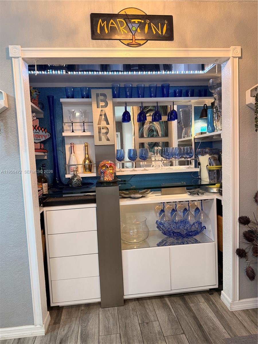 A home bar area features white cabinetry, blue glassware, a mirror, and a martini sign — 309 NW 15th St, Homestead FL 33030, HOMESTEAD, FL