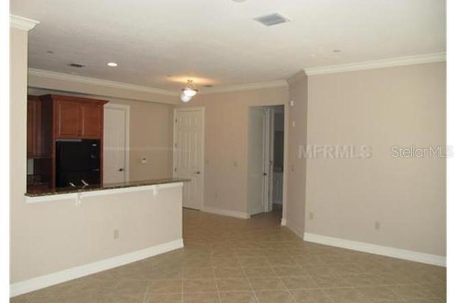 An interior view shows a kitchen with dark wood cabinets and a breakfast bar counter — 619 FRONT STREET UNIT 3104, CELEBRATION, FL