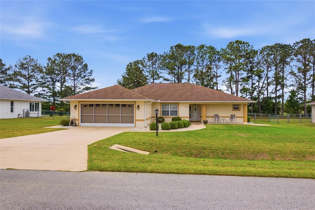 A single-story tan house with a two-car garage and a large grassy front yard — 4772 NW 30TH PLACE, OCALA, FL