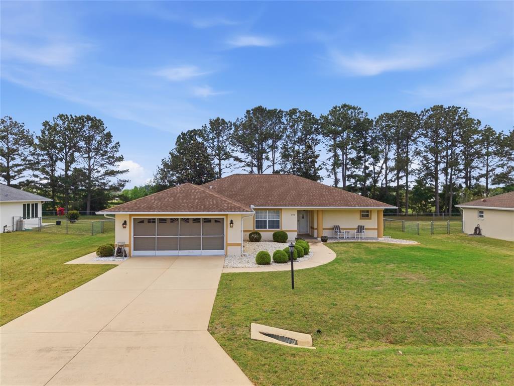 A single-story house with a tan exterior, a brown roof, and a concrete driveway — 4772 NW 30TH PLACE, OCALA, FL