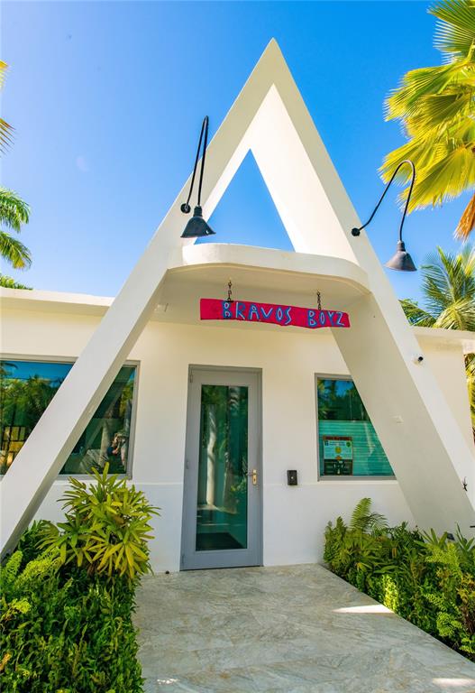 The exterior of a white building features a triangular frame, a glass door, and signage — 300 PALM COTTAGES, VIEQUES, PR