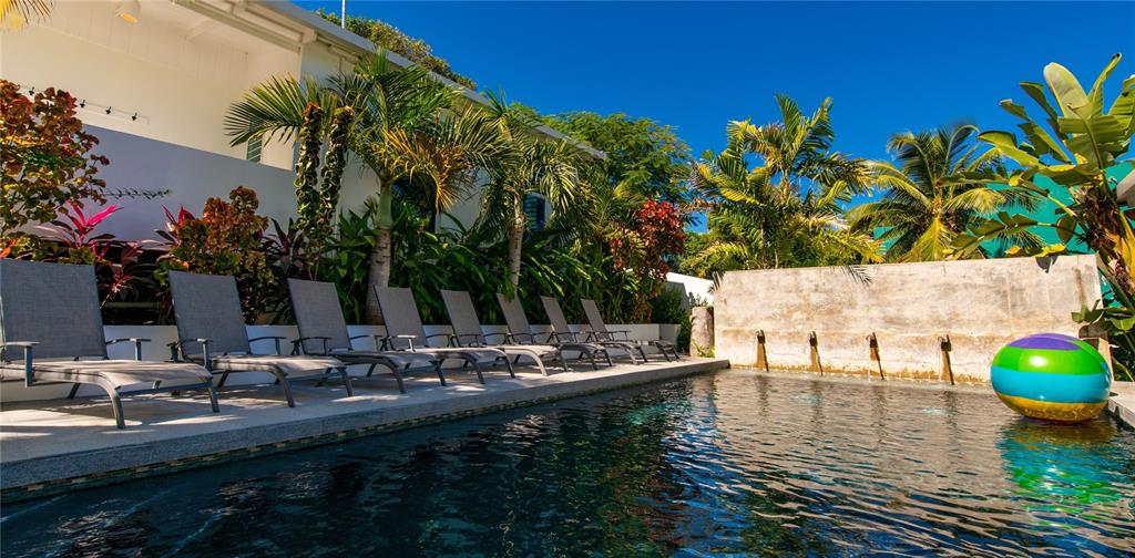 A swimming pool with lounge chairs and a beach ball sits beside a building — 300 PALM COTTAGES, VIEQUES, PR
