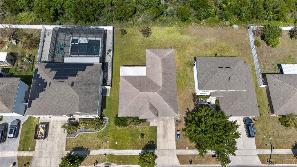 An aerial view shows three suburban houses with driveways, lawns, and a screened-in pool — 4020 SUNNY DAY WAY, KISSIMMEE, FL