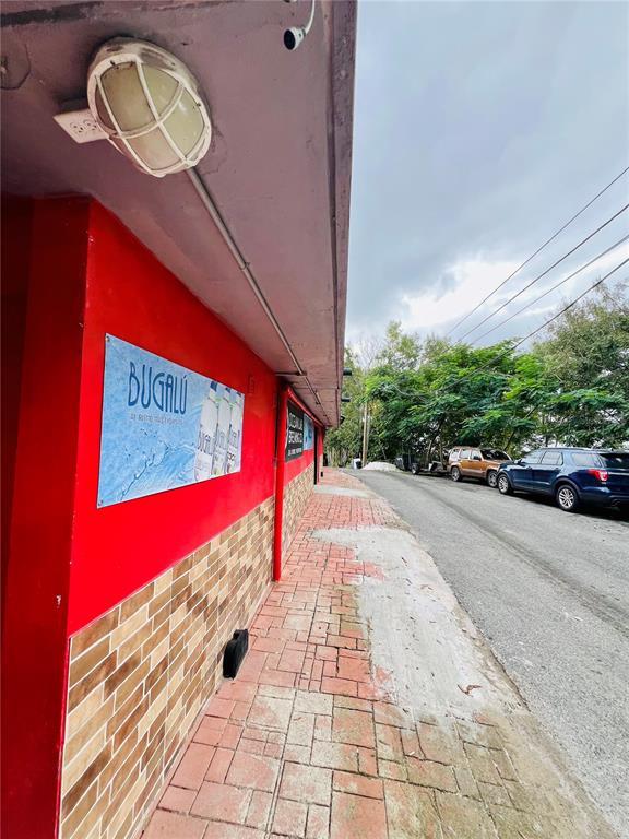 A red building exterior with a brick facade and a paved walkway along a road — 149 ROUTE UNIT KM 18.3, CIALES, PR