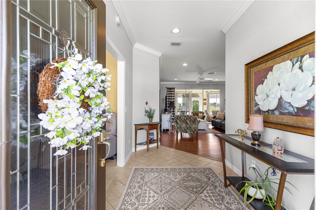 A view from an entryway into a living room with tile and wood flooring — 11855 SE 91ST CIRCLE, SUMMERFIELD, FL
