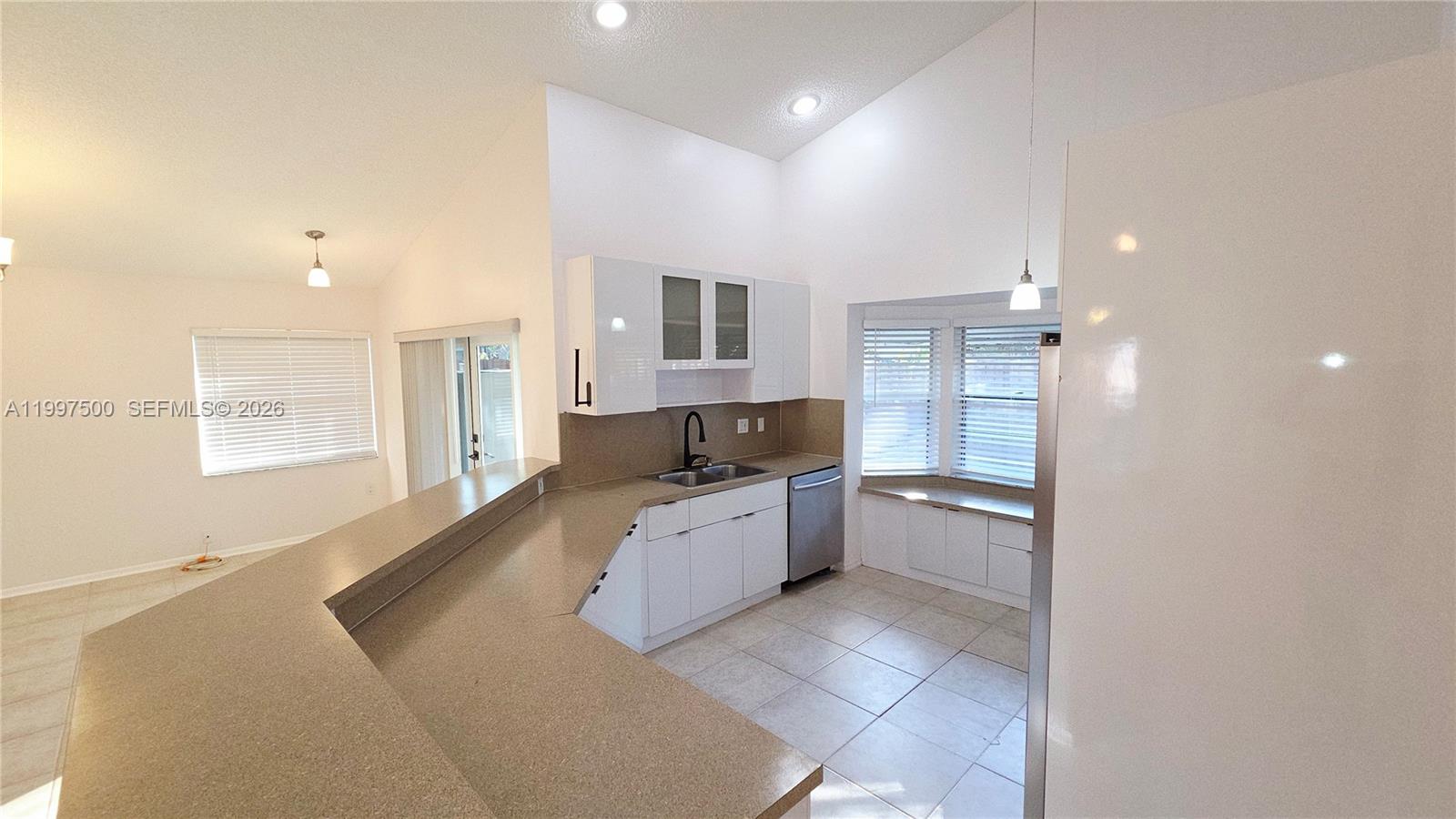 A kitchen features white cabinets, a breakfast bar, and a built-in window seat — 3247 NW 123rd Ave, Sunrise FL 33323, SUNRISE, FL