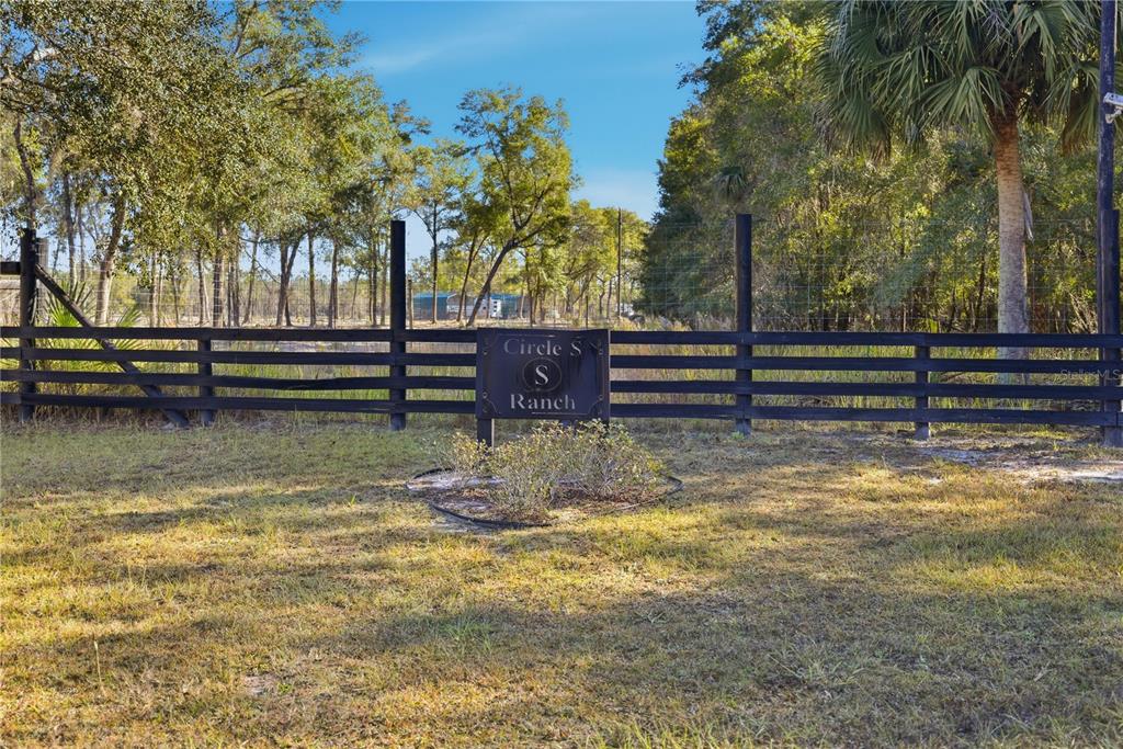 A black wooden fence surrounds a grassy field with a Circle S Ranch sign — TBD (Lot 1) NE 115TH LANE ROAD, FORT MC COY, FL