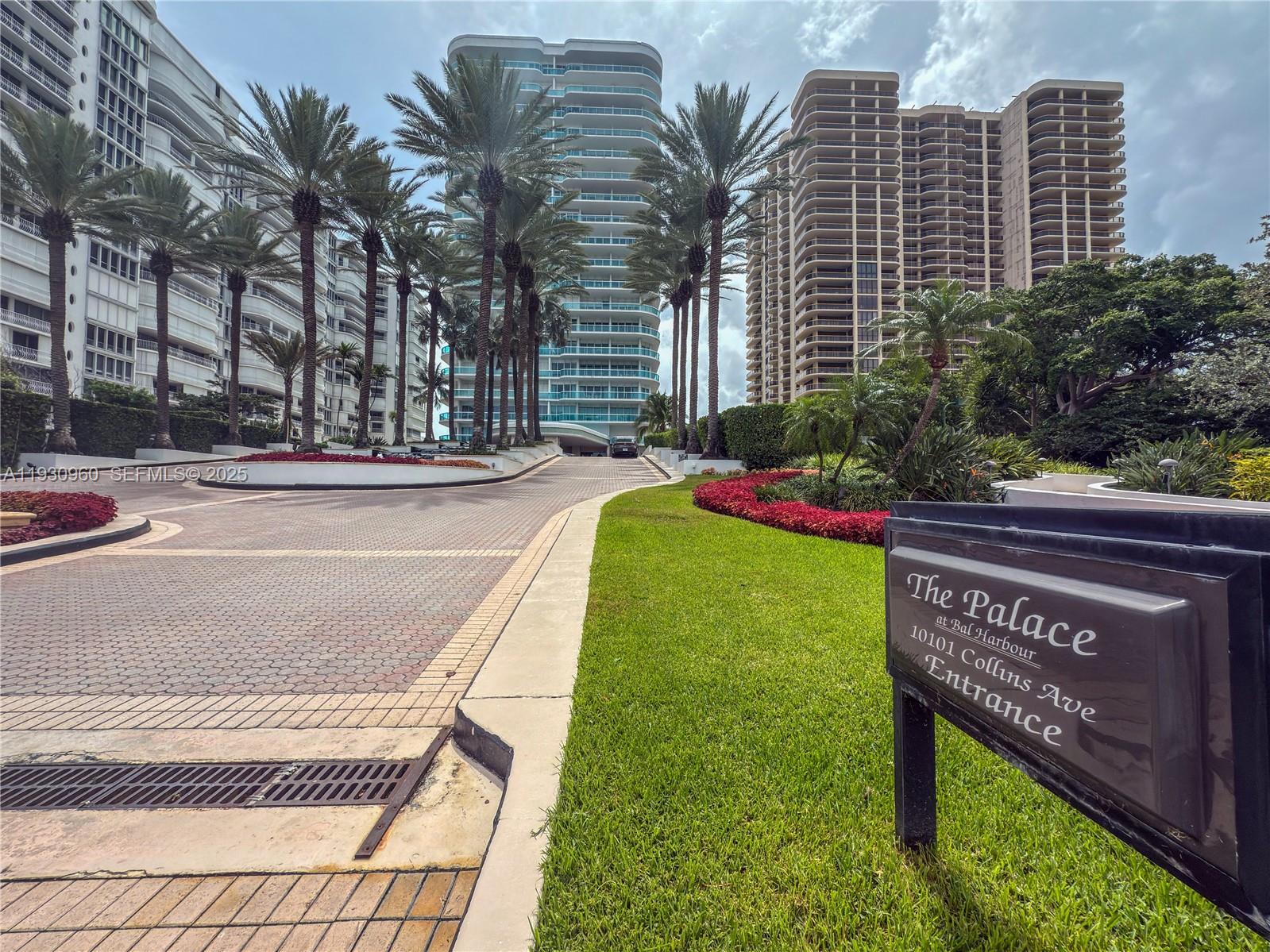 The entrance to a residential complex features a paved driveway, palm trees, and landscaping — 10101 Collins Ave # 4A, Bal Harbour FL 33154, BAL HARBOUR, FL