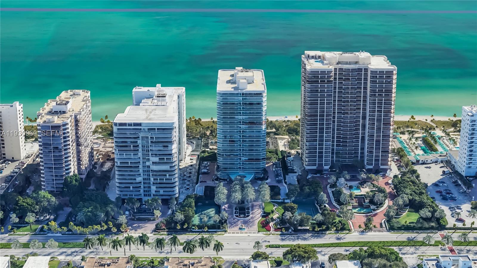 An aerial view shows four high-rise residential buildings situated along a sandy beach and ocean — 10101 Collins Ave # 4A, Bal Harbour FL 33154, BAL HARBOUR, FL