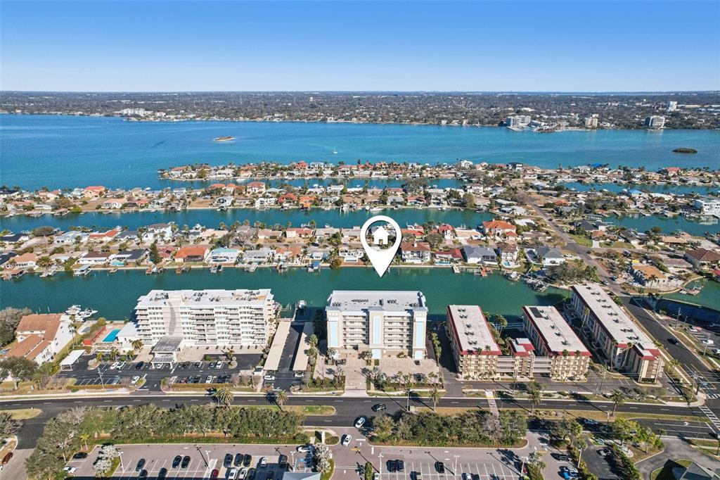 A balcony view overlooking a canal with boat docks and houses under a sunset sky — 125 ISLAND WAY UNIT 404, CLEARWATER BEACH, FL