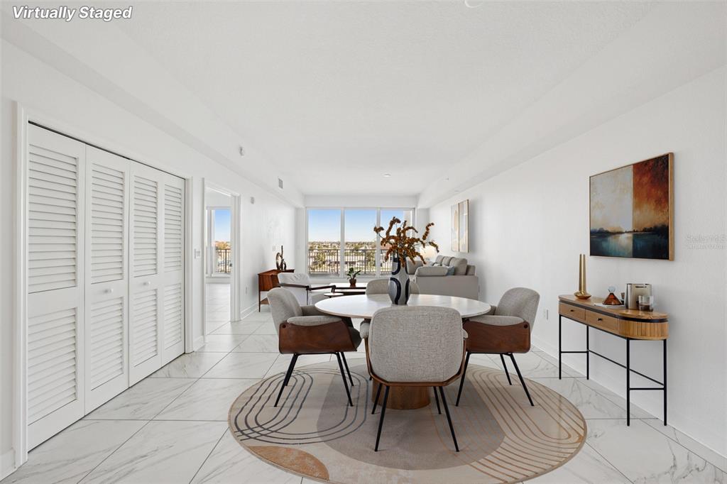 A dining area with a round table and chairs sits on a patterned rug — 125 ISLAND WAY UNIT 404, CLEARWATER BEACH, FL