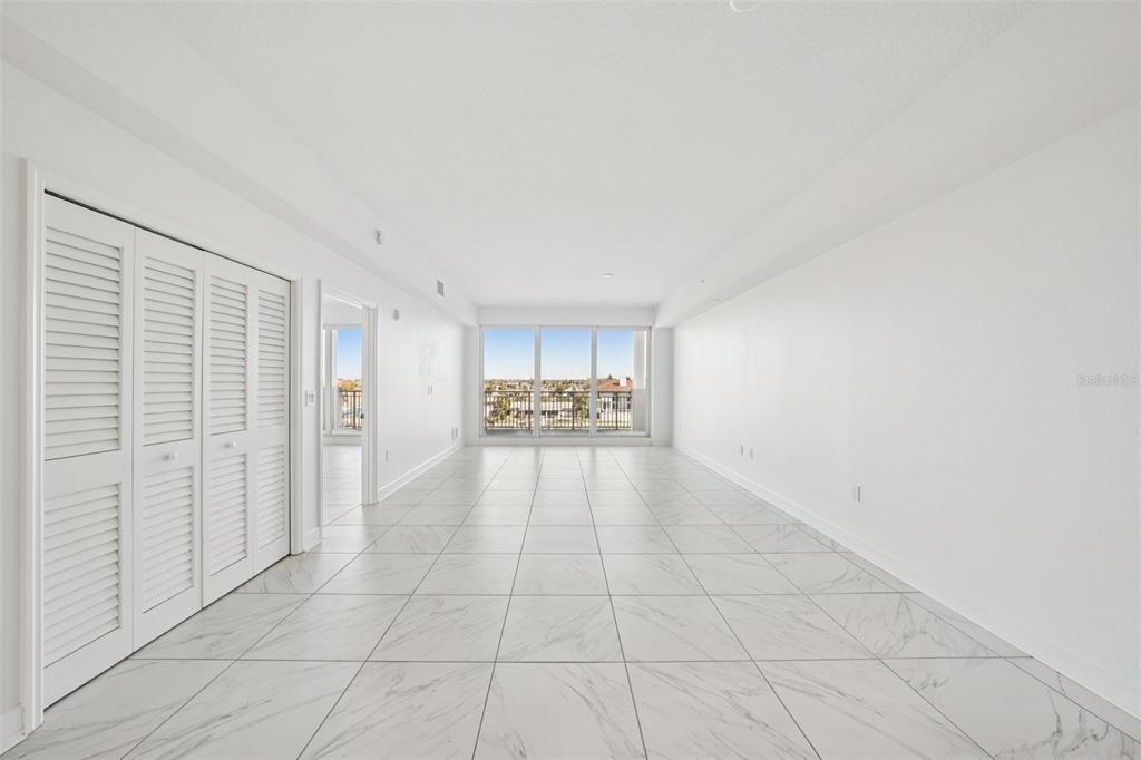 An empty, white-walled room with marble-patterned tile flooring and a balcony view — 125 ISLAND WAY UNIT 404, CLEARWATER BEACH, FL