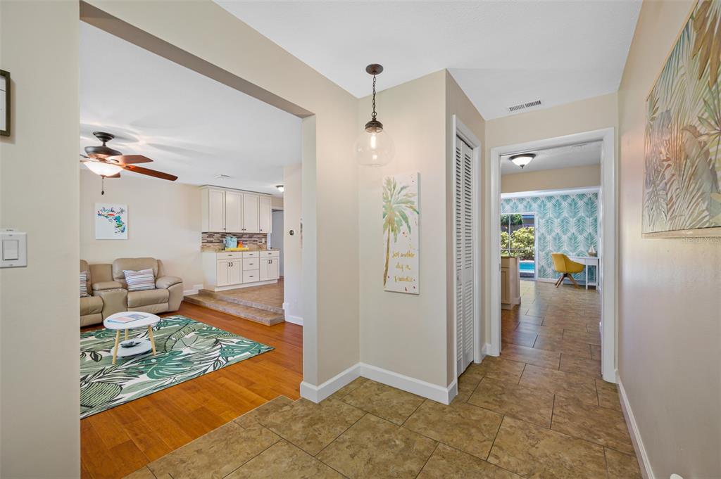 A tiled entryway leads to a living room with hardwood floors and a kitchen beyond — 3749 MCKAY CREEK DRIVE, LARGO, FL