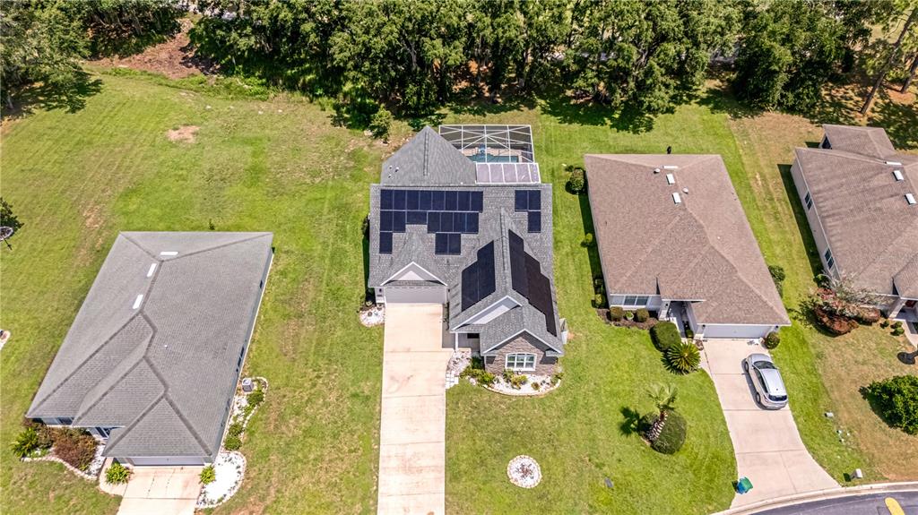 An aerial view shows a house with solar panels on the roof and a pool — 728 LAKE DIAMOND AVENUE, OCALA, FL
