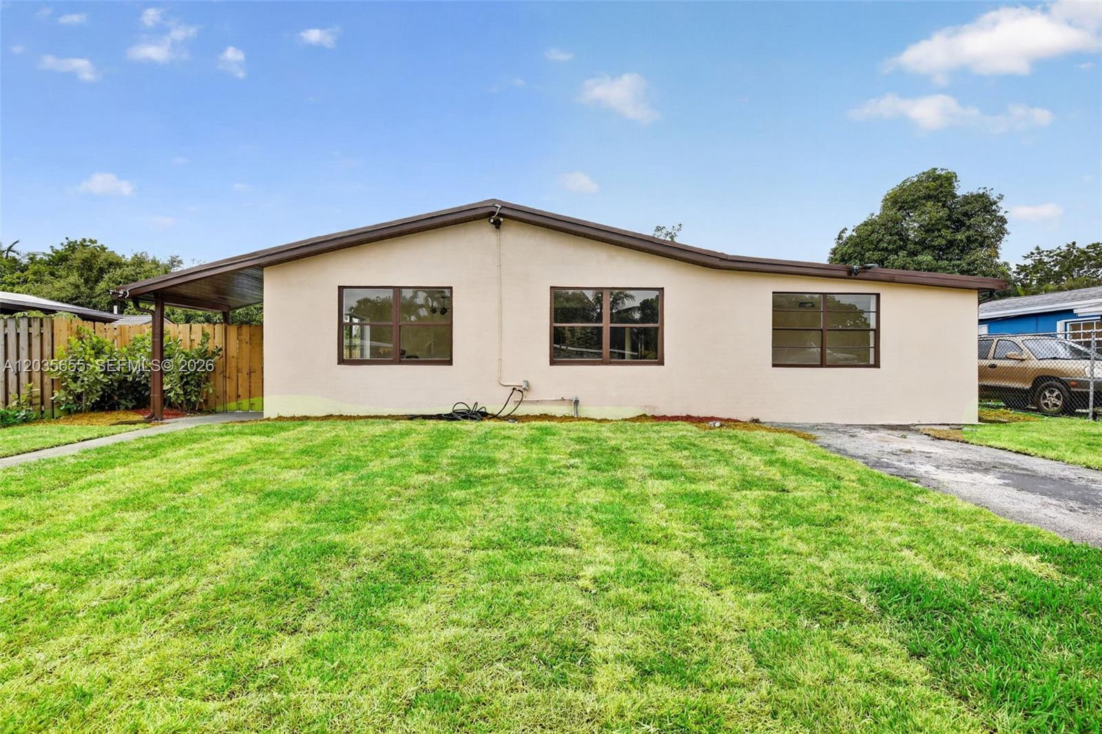 A single-story house with a beige stucco exterior, brown trim, and a front lawn — 6250 NW 14th St, Sunrise FL 33313, SUNRISE, FL